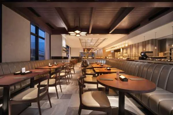 Long restaurant banquette with loose tables and individual dining chairs