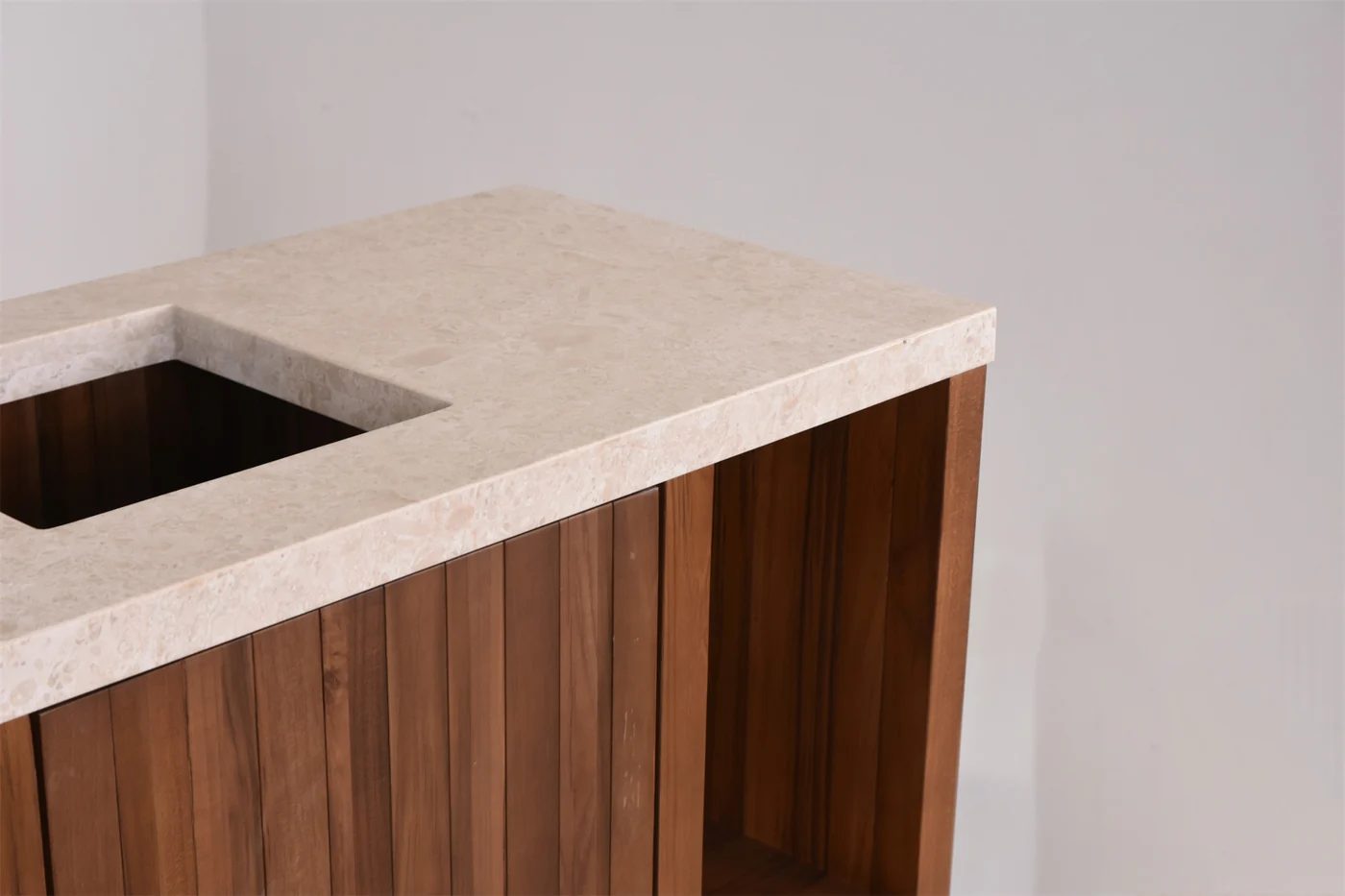 Pale stone-like cabinet top with an opening and wood-toned slatted panels