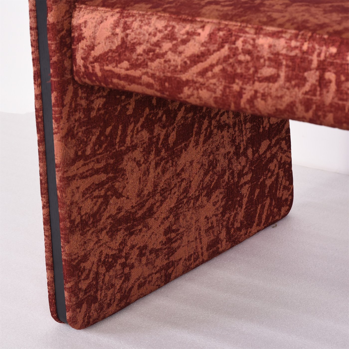 Close view of light upholstery meeting a shaped timber-colored chair arm