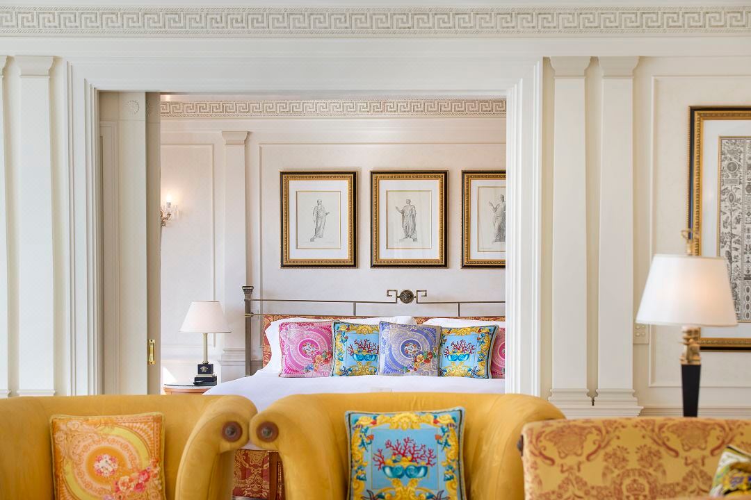 Hospitality interior with a bed, lounge seating, lamps and architectural trim