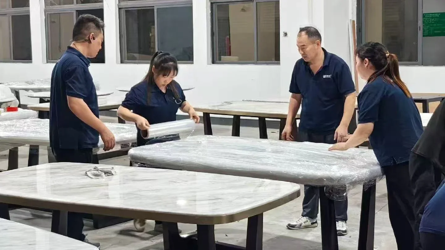 Gainwell staff wrapping furniture surfaces before shipment