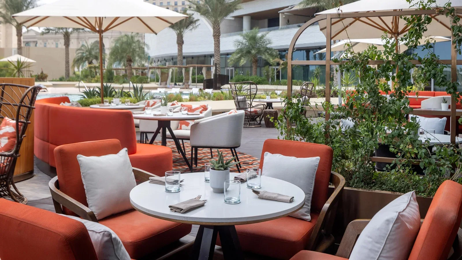 Outdoor hotel dining area with seating, tables and umbrellas