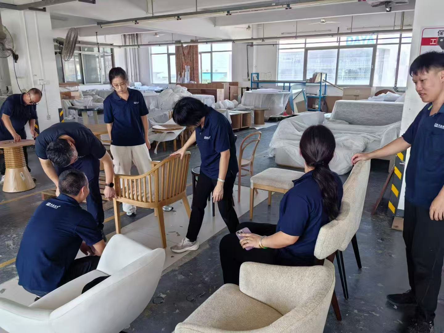 Gainwell team members reviewing several furniture items on the factory floor