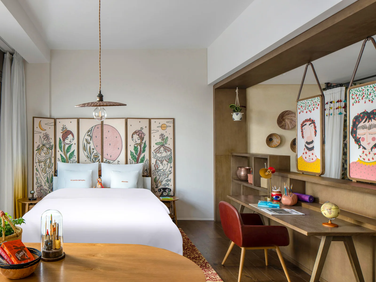 Hotel guestroom with bed, desk, chair, shelving and bedside tables