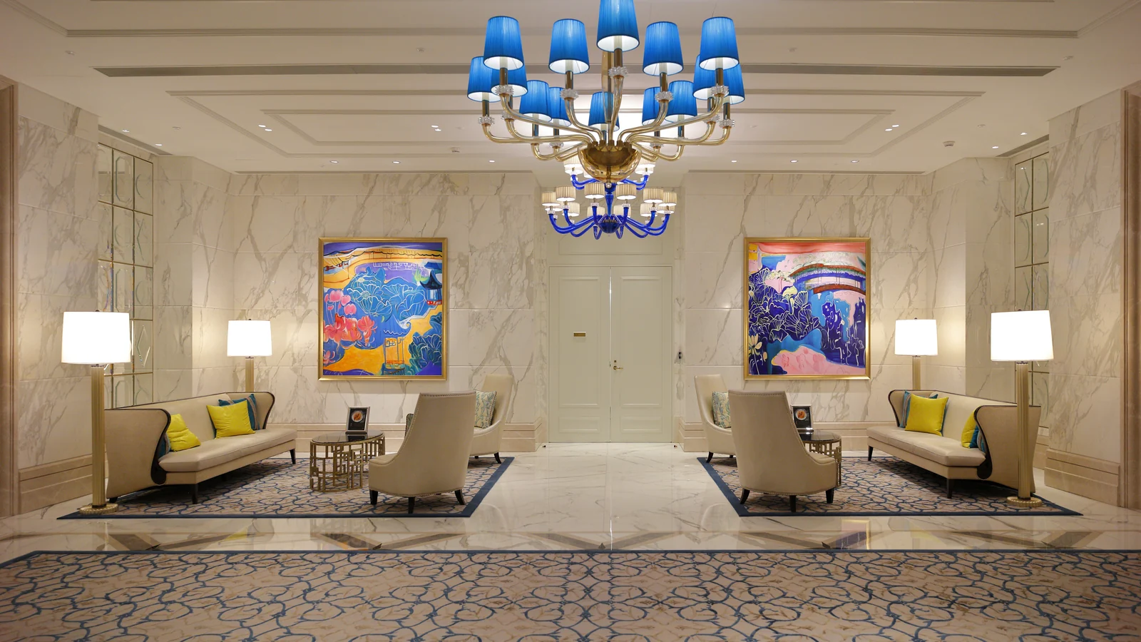 Hotel lobby edge seating groups arranged around a central doorway