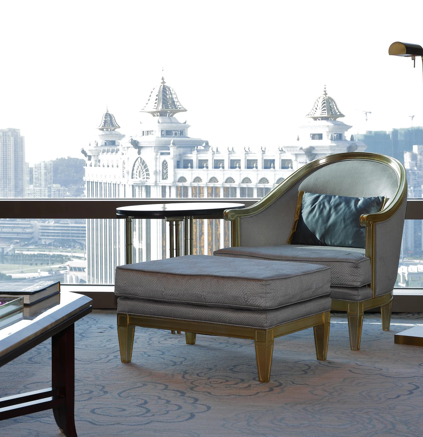 Upholstered lounge chair, ottoman and side table in a hotel seating area
