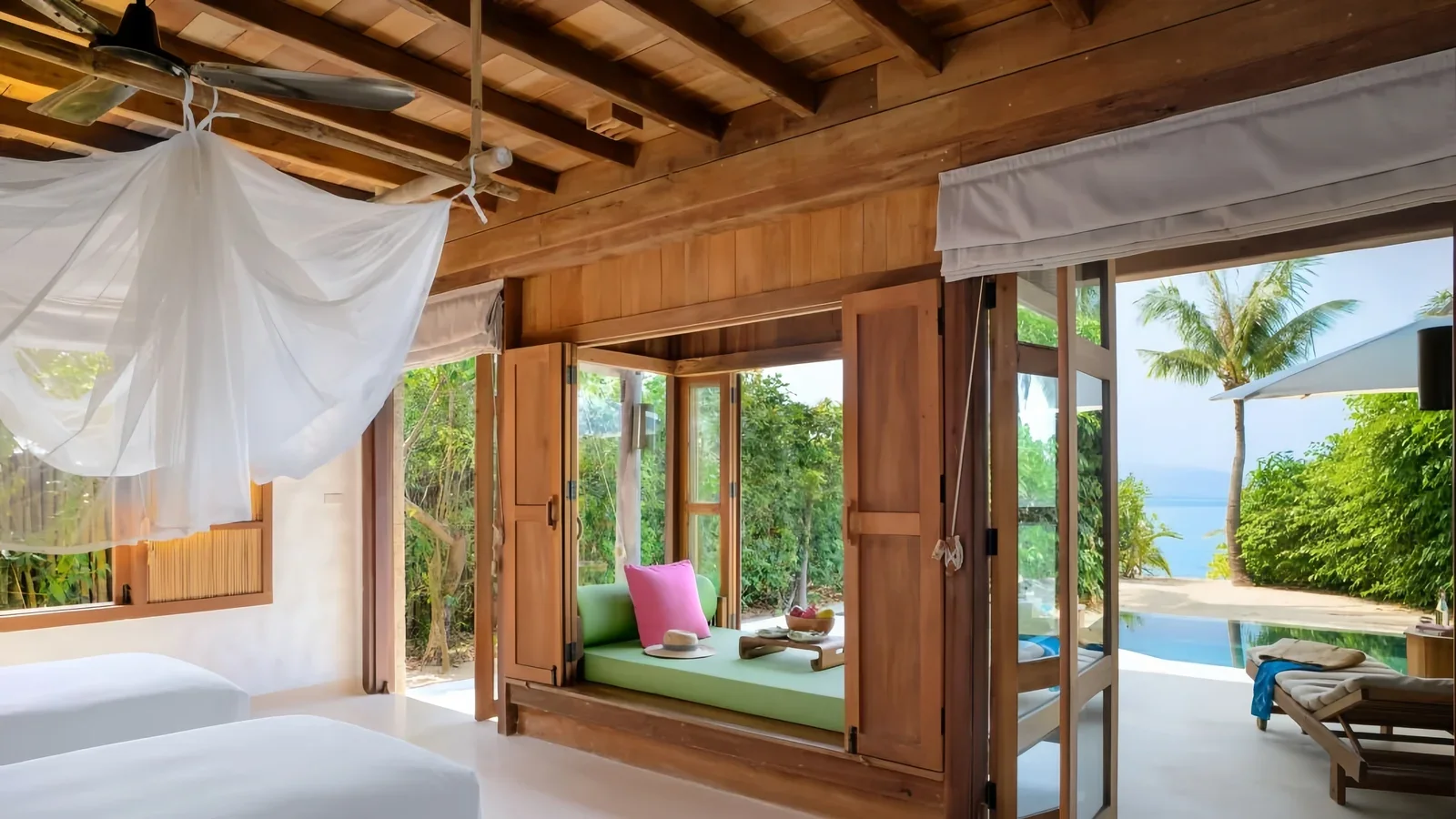 Mixed furniture surfaces beside an indoor-to-poolside boundary