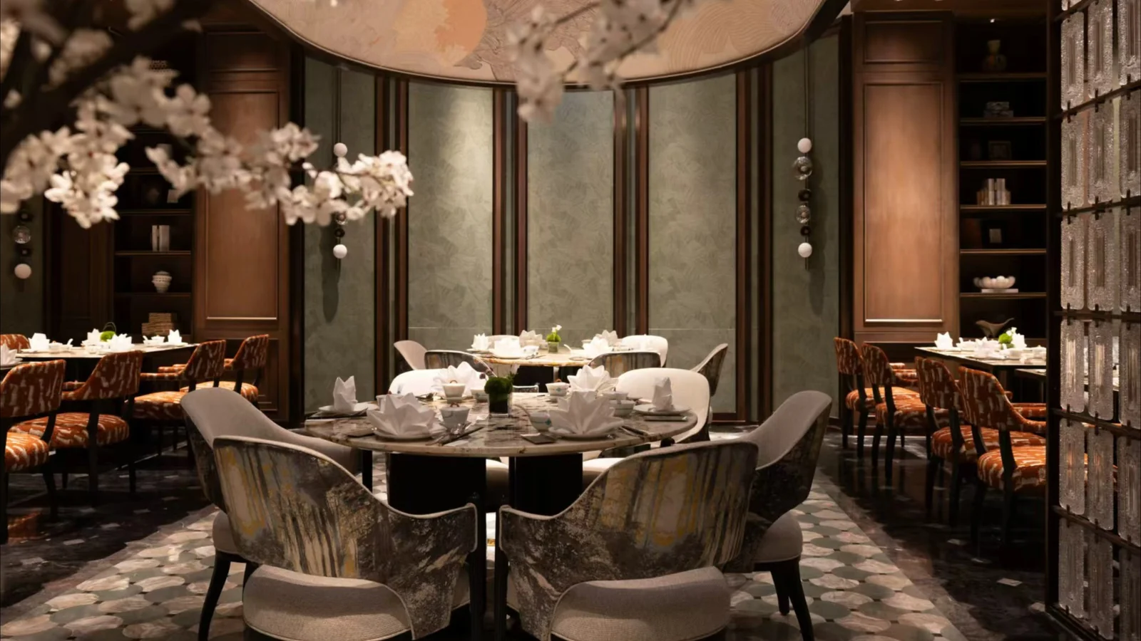 Restaurant dining room with upholstered chairs, patterned tabletops and coordinated wall finishes