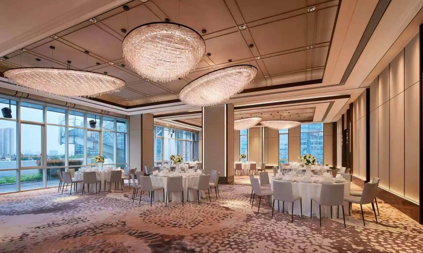 Round dining tables and loose chairs arranged across a large hospitality room