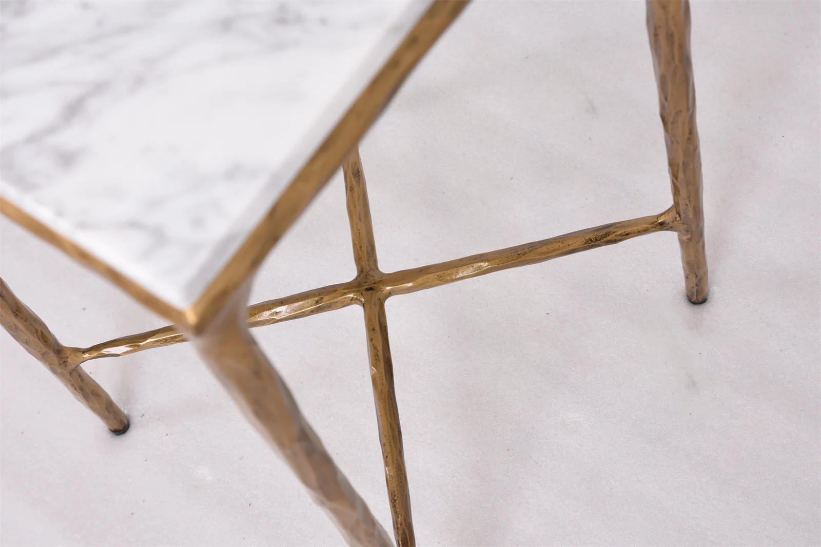 Light patterned tabletop above a textured bronze-colored metal support frame