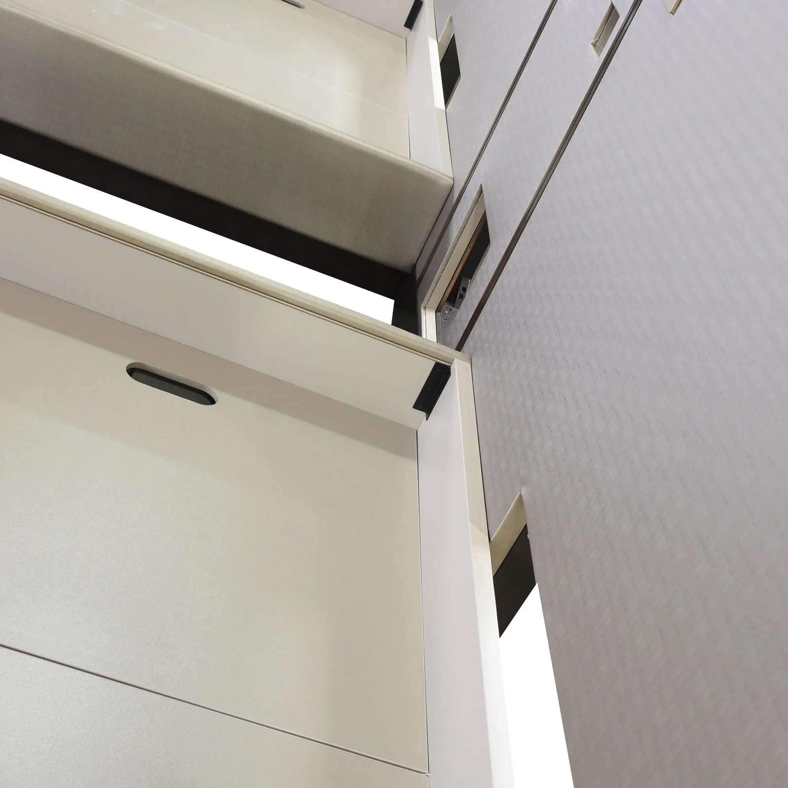 Rear-side headboard panel junction with dark frame pieces and a small bracket
