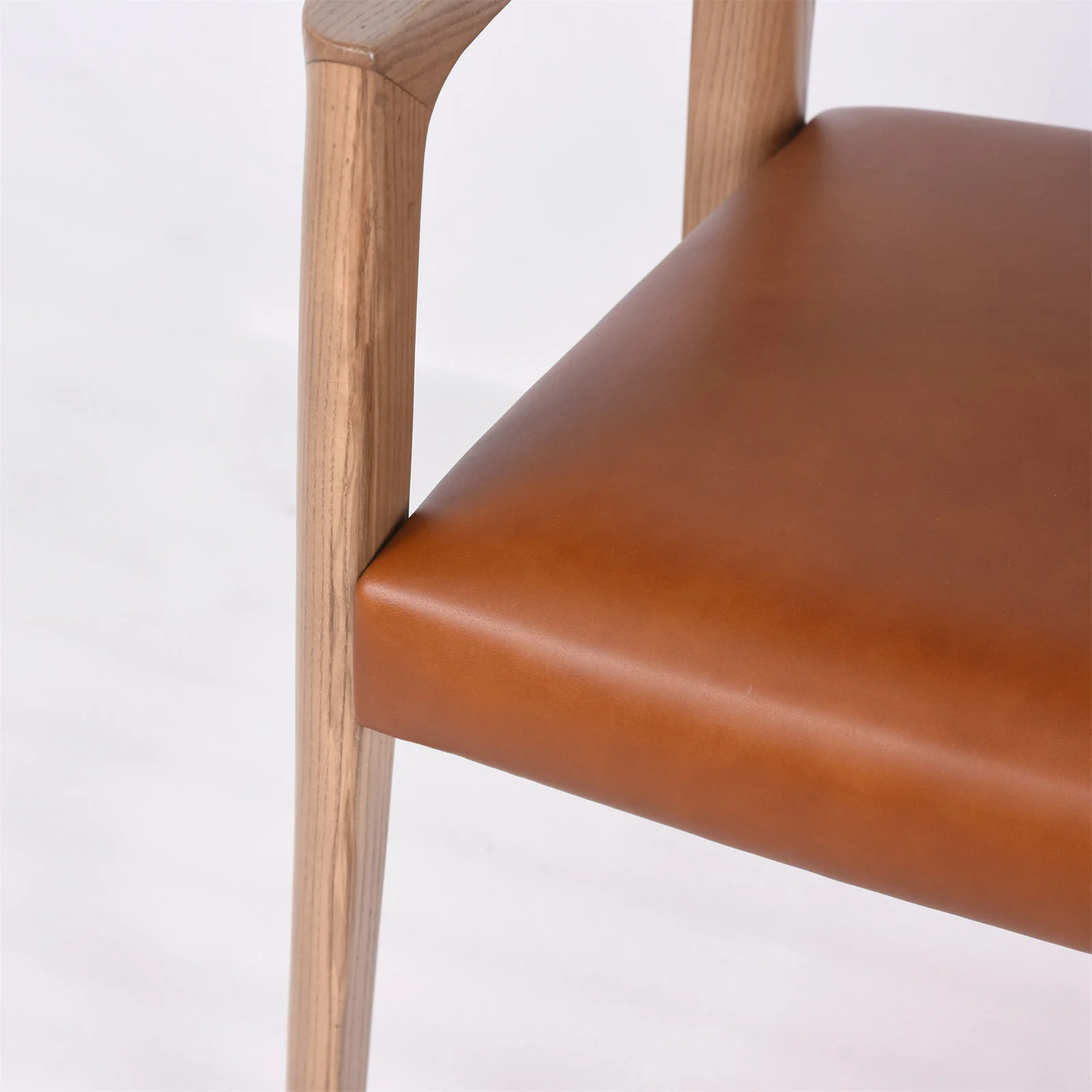 Brown upholstered restaurant chair seat with a pale timber-colored frame detail