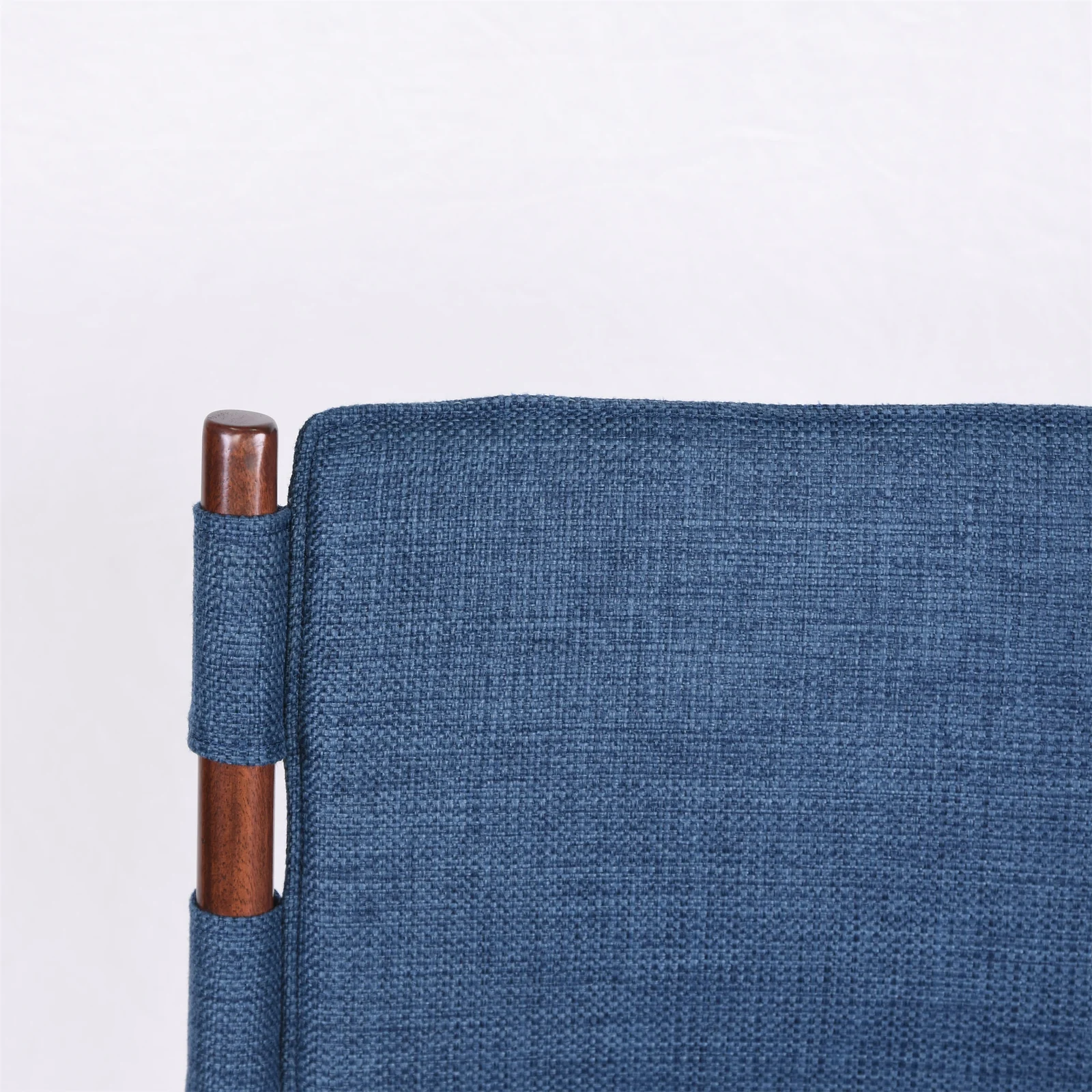 Close view of a blue upholstered restaurant chair back and frame