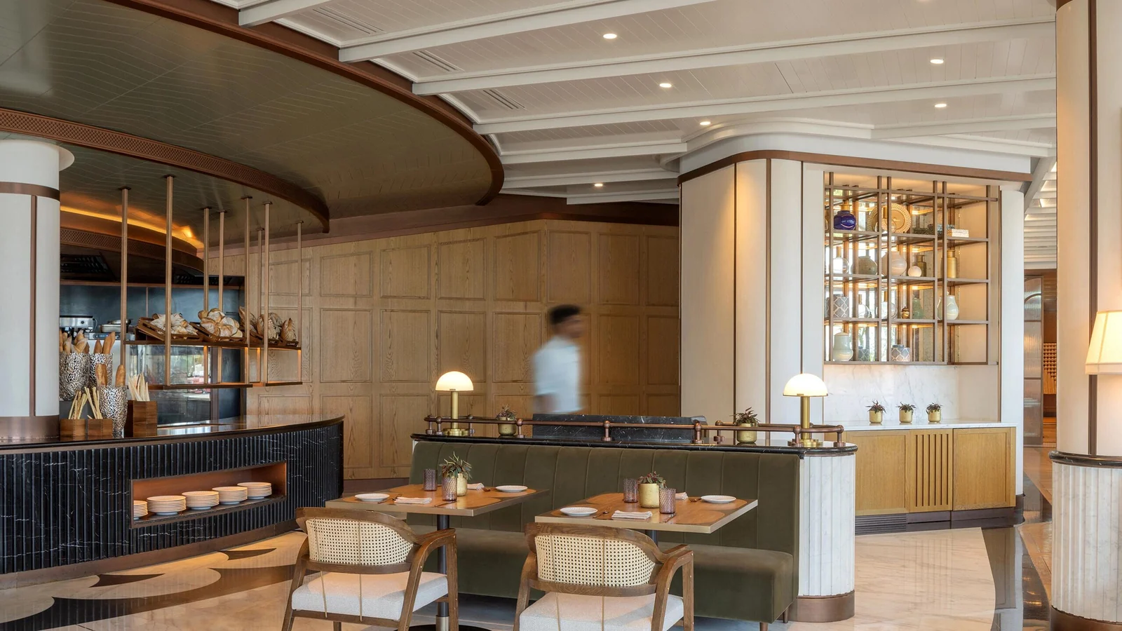 Hospitality dining space with timber-toned furniture and wall panels under project lighting