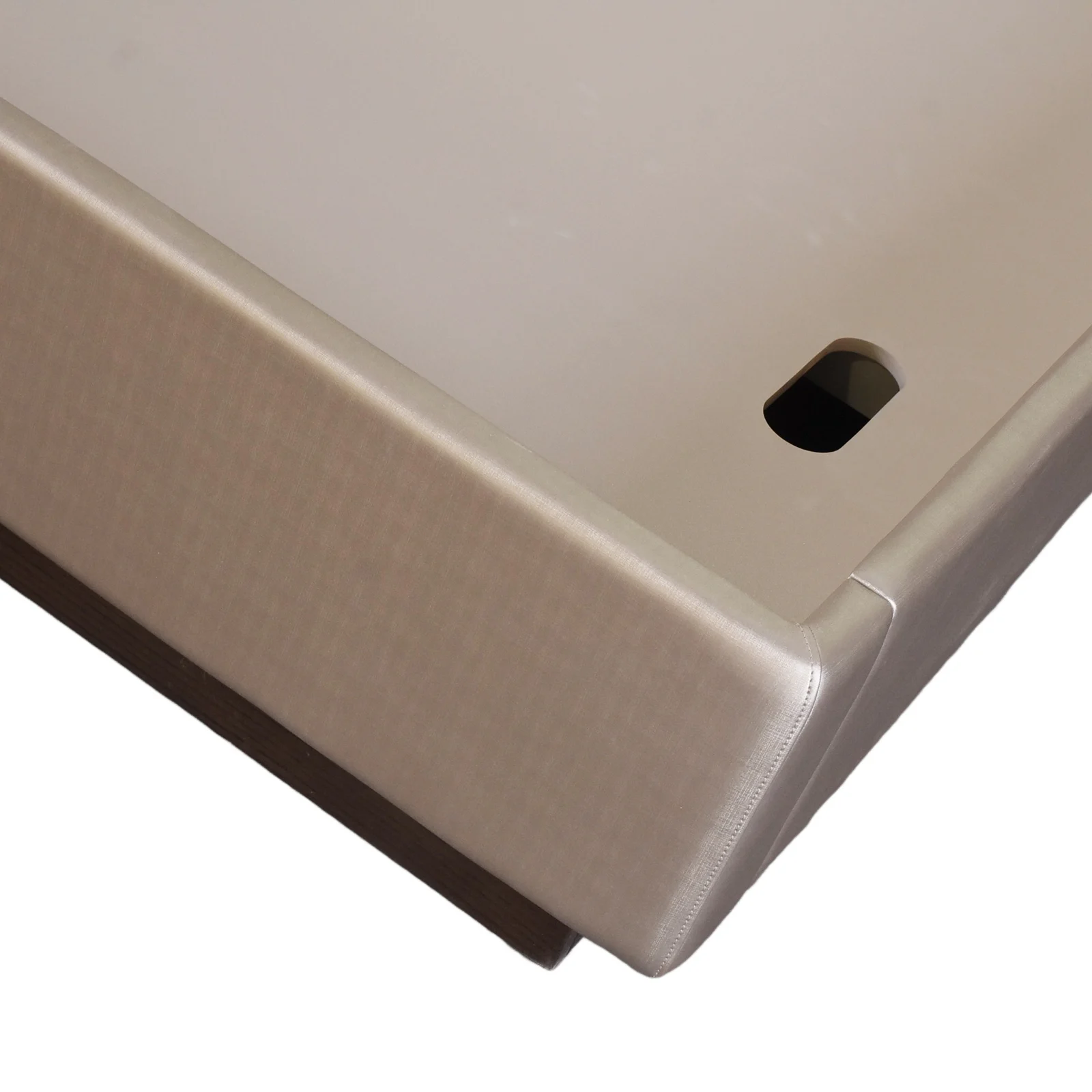 Close-up of a wrapped bed edge with a stitched corner and dark base transition