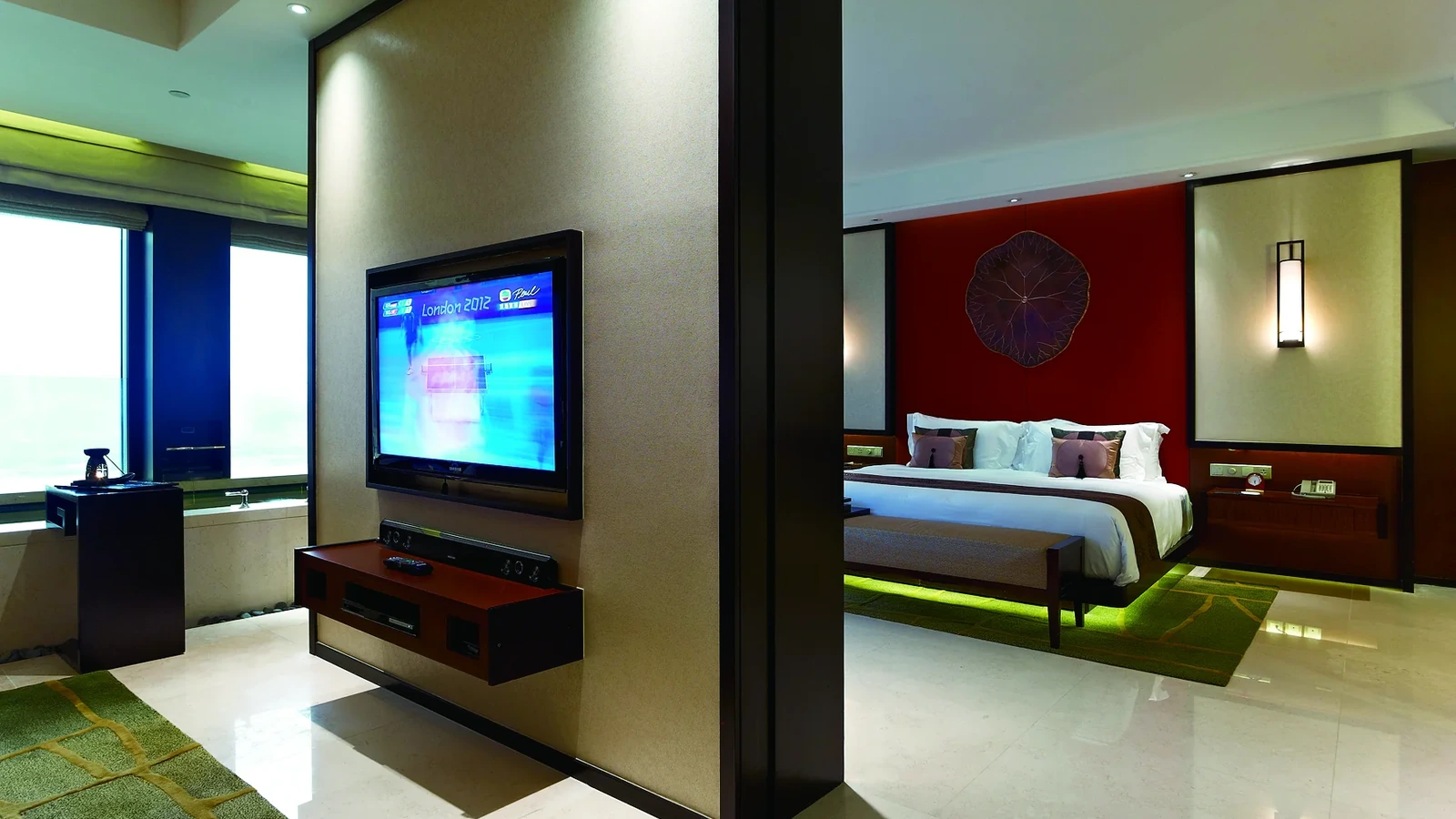 Wall-mounted media cabinet beside a hotel guestroom partition