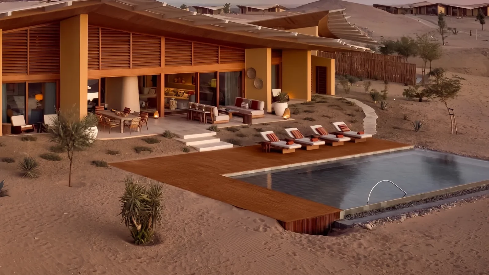 Covered villa terrace and exposed poolside loungers at dusk